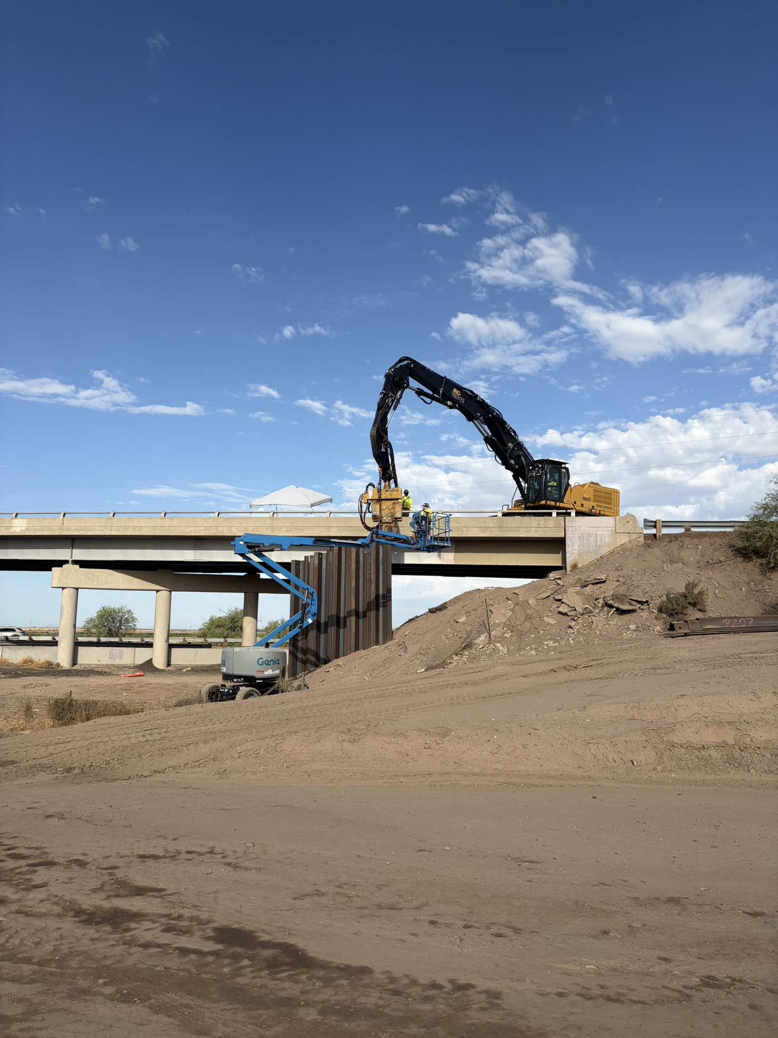 Workers using construction equipment on the bridge